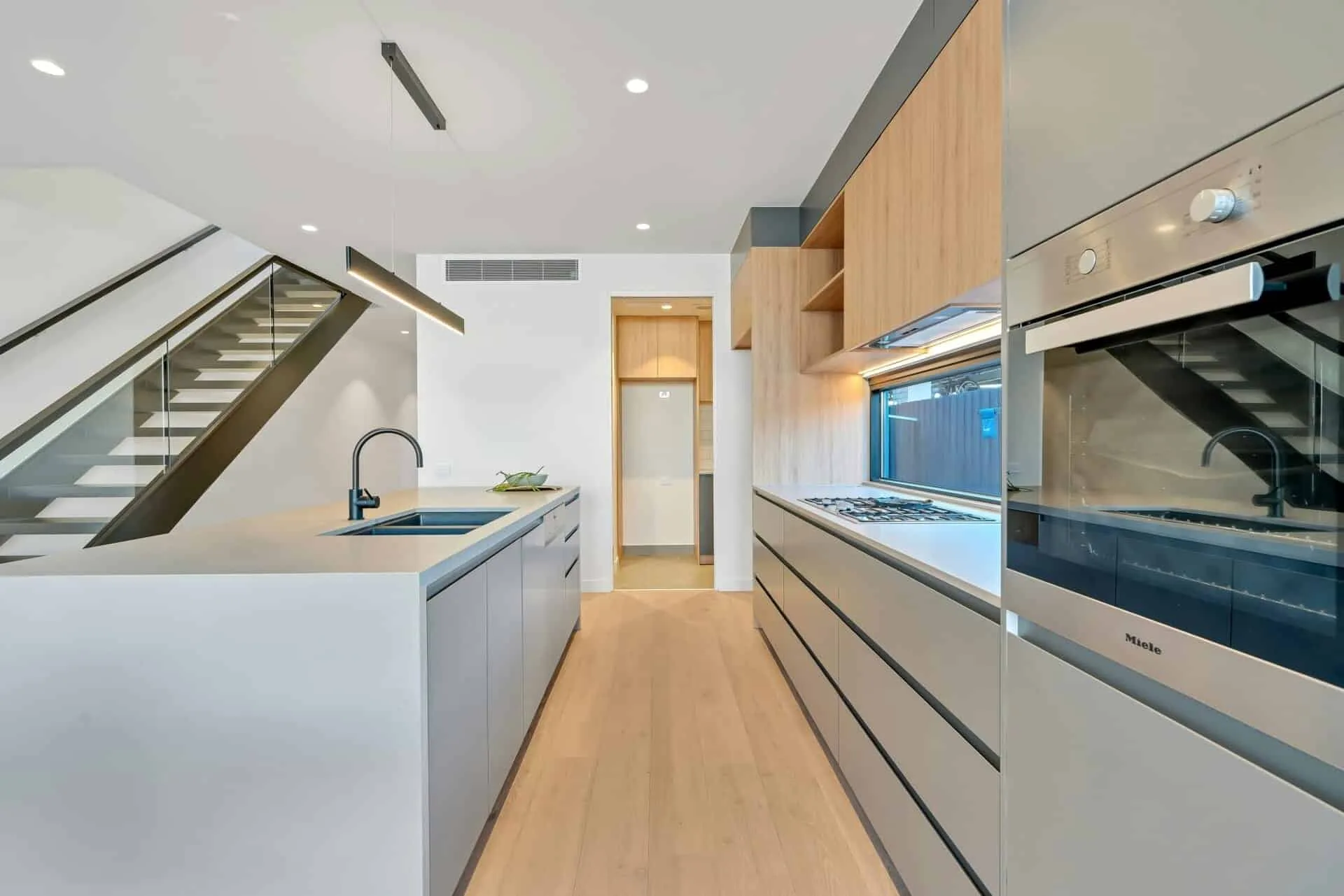 Modern kitchen with sleek cabinetry, built-in oven, and minimalistic design elements.
